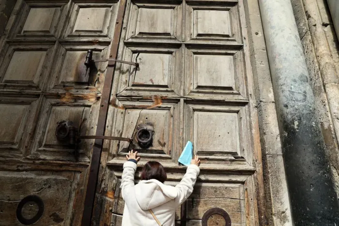 Framed Print : A worshipper touches the closed doors of the Church of the Holy Sepulchre in Jerusalem s Framed Print : A worshipper touches the closed doors of the Church of the Holy Sepulchre in Jerusalem s