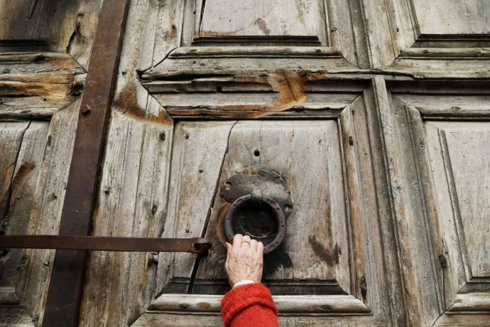 Framed Print : A worshipper touches the closed doors of the Church of the Holy Sepulchre in Jerusalem s