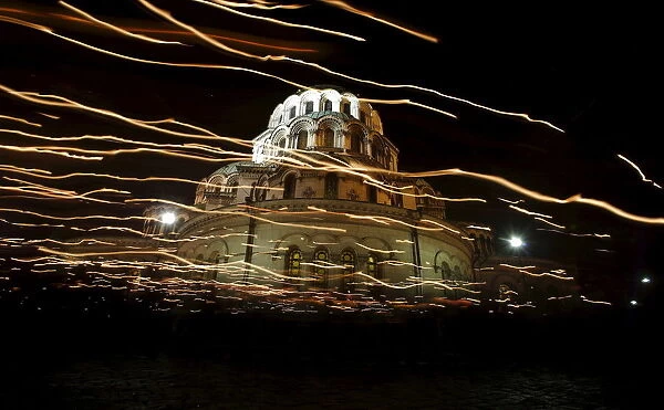 Worshippers walk with candles around the golden-domed Alexander Nevski cathedral during