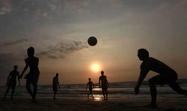 Youths play volleyball on the beach in Colombo