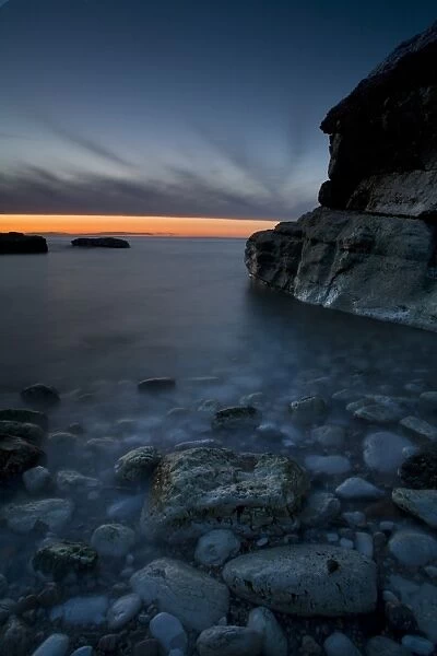 Bay with pebbles on beach, on chalk headland at sunset, Thornwick Bay, Flamborough Head, North Yorkshire, England, may