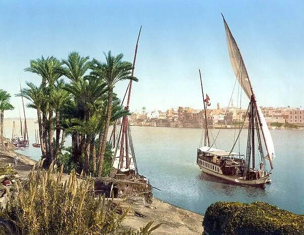 EGYPT: CAIRO. A sailboat on the Nile River with the city in the background, Cairo, Egypt