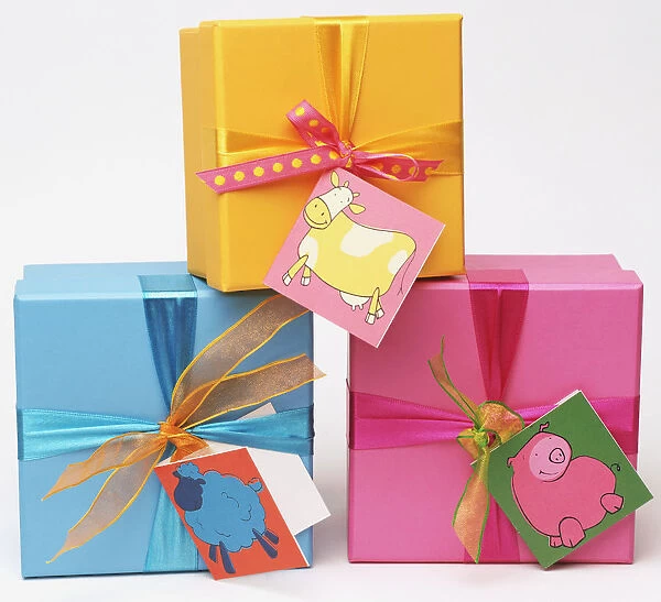 Three gift boxes with bows and animals tags, stacked on their sides in pyramid