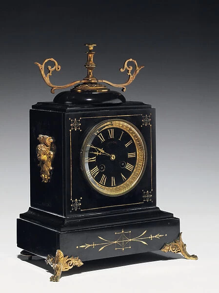 A mantle clock of black composition stone, with incised decoration, with legs