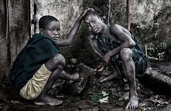 Surma boy painting the face of his friend - Ethiopia
