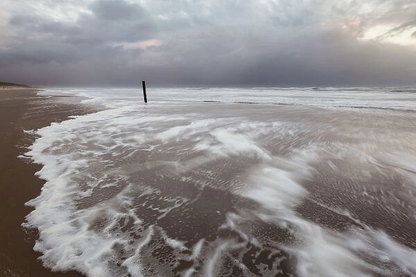 Foam on North Sea beach at stormy winter day, North Sea beach, the Netherlands