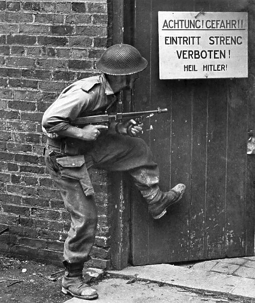 British Army Soldier uses a tommy gun while training to storm a mockup german building