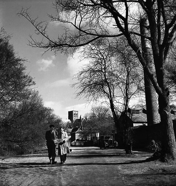 Two men walking through the park in St. Albans with the cathedral in the background