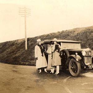 Women standing by large car