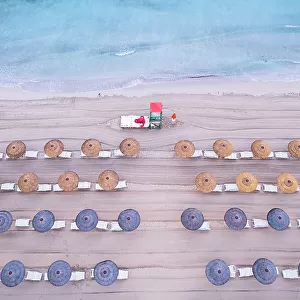 Aerial view of rows of beach umbrellas with a lifeguard tower on an sandy beach, Sicily island, Italy, Mediterranean Sea, Europe