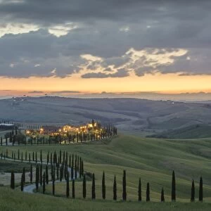 Dusk on green hills surrounded by cypresses and farm houses, Crete Senesi (Senese Clays)