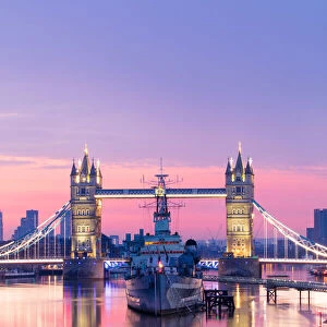 Sunrise view of HMS Belfast and Tower Bridge reflected in River Thames
