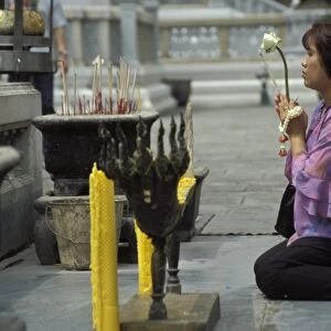 Thai Buddhist woman praying at temple