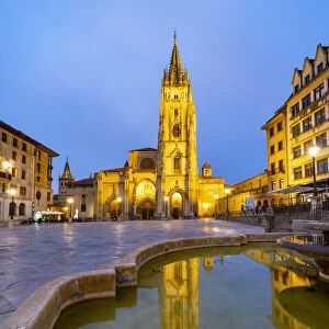 Cathedral of San Salvador in Oviedo reflected in the fountain of Plaza Alfonso II el Casto by night. Oviedo, Asturias, Spain