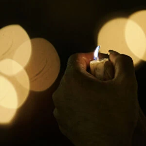 An activist holds a candle during celebrations of the International Day of Peace in