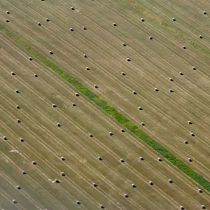Aerial view of bales of straw on a harvested grain field in Brandenburg state