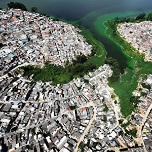 An aerial view shows illegally built slums on the border of the polluted water of