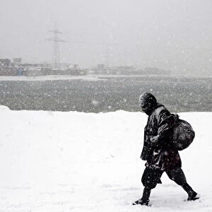 An Afghan man walks during a snowy day in Kabul