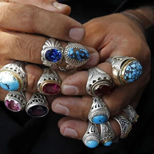 Afghan vendor wears rings on his fingers to attract customers ahead of Eid-al-Fitr in