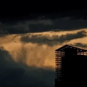 An aircraft flies past a building under construction on a stormy evening in Moscow An aircraft flies past a building under construction on a stormy evening in Moscow