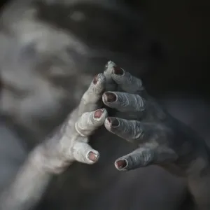 Ash-encrusted hands of a sadhu are seen as he sits beside a fire after applying ashes to his face Ash-encrusted hands of a sadhu are seen as he sits beside a fire after applying ashes to his face