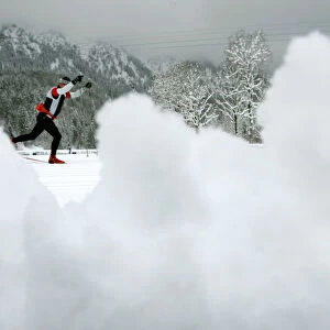 An athlete tries to make his way after heavy snow falls at the cross country race track for the