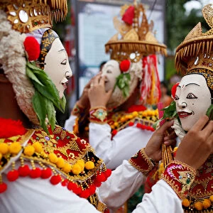 Balinese Hindus wear masks as they prepare before performing sacred Telek dance at
