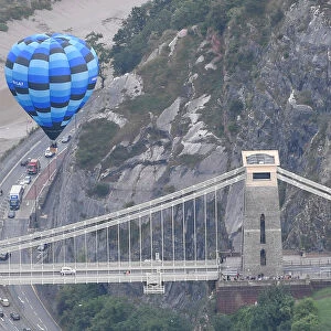 A balloon flies near the Clifton Suspension Bridge during a mass take off at the annual
