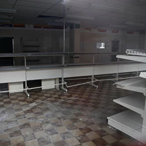 Bare shelves are seen inside a closed down retail unit in Stockport, near Manchester