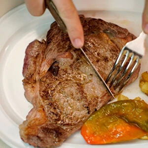 A beef steak is cut at the Taberna del Gijon restaurant in Madrid