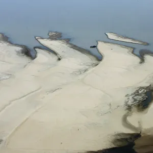 A boat moors to a sand bar exposed by the receding waters of the Rio Solimoes river A boat moors to a sand bar exposed by the receding waters of the Rio Solimoes river