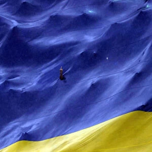 A Boca Juniors fan makes a gesture from a hole in a giant flag before their Argentine