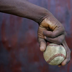 A boy holds on to a ball during a baseball training session in Haina