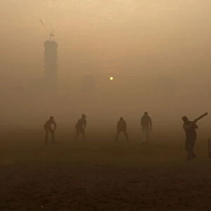 Boys play cricket in a public park amidst heavy fog on a cold winter morning in Kolkata