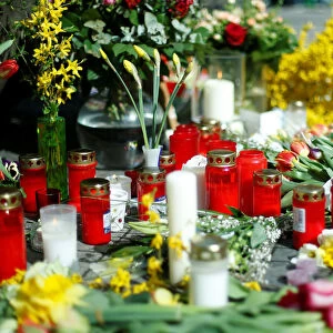 Candles and flowers are placed at the site where, on April 7