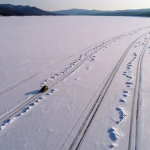 A car drives along a road on the frozen Yenisei River at sunset, south of Krasnoyarsk A car drives along a road on the frozen Yenisei River at sunset, south of Krasnoyarsk