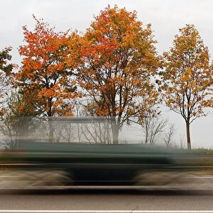 Car speeds alongside autumn trees near village of Zaslavl