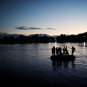 Central American migrants cross the Suchiate river into Mexico on a raft as they try to