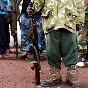A former child soldier holds a gun as they participate in a child soldiers release ceremony