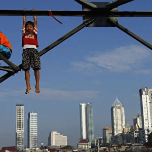 Children play at an electricity pylon in Jakarta