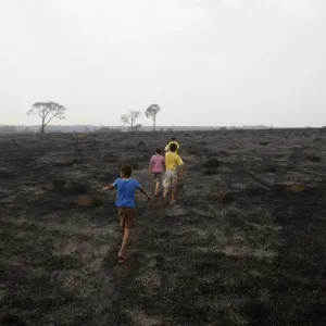 Children walk on a burned area of Chapada dos Guimaraes in midwesten Brazil Children walk on a burned area of Chapada dos Guimaraes in midwesten Brazil
