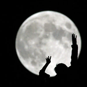 A Chinese boy plays during a full moon night in Shanghai