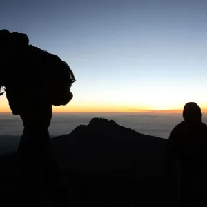 Climbers walk up the steep gravel and scree slope leading to the summit of Tanzania s