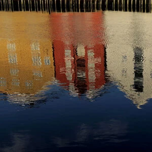 Coloured houses are reflected on the waterfront in Trondheim