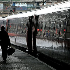 Commuter walks to board a train at Kings Cross station in central London
