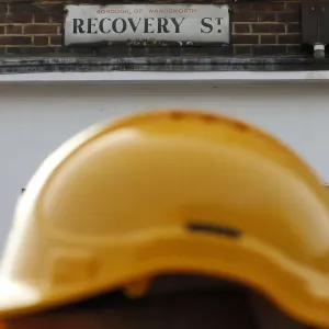 A construction worker walks past a street sign in south London