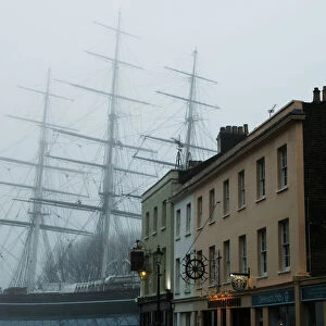 The Cutty Sark is pictured behind buildings at Greenwich in London