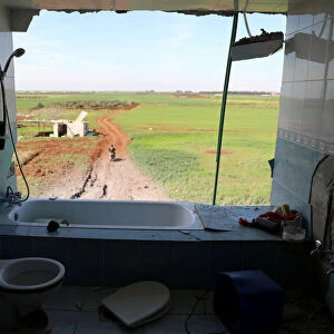 Damaged bathroom in a house, in al-Harak town, near Deraa