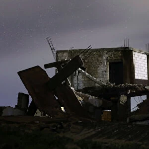 Damaged houses are pictured at night in the rebel-held area, in the city of Daraa, Syria