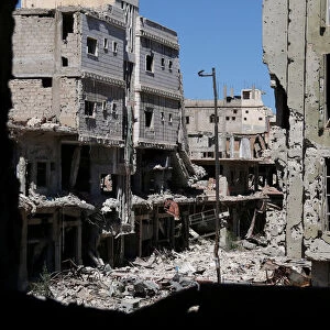 Debris from damaged buildings are seen from a hole at a rebel-held area in Deraa